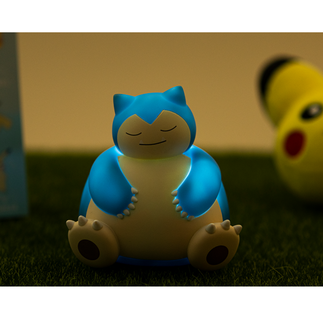 Cute sleeping Snorlax Pokémon LED night light glowing in blue, placed on grass with a soft peaceful ambiance, perfect for kids’ bedrooms, nursery décor, or Pokémon fan collections.