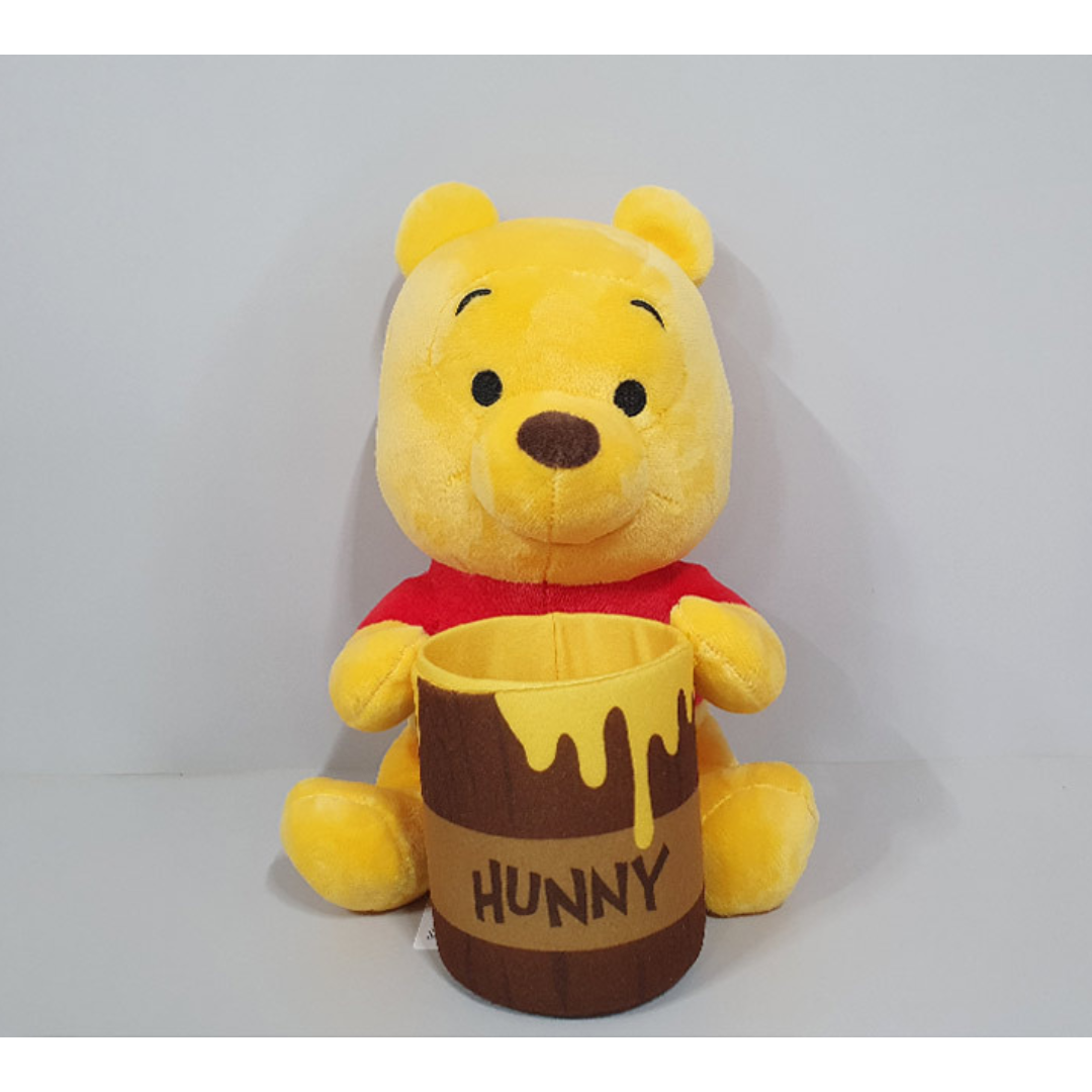 Winnie the Pooh plush toy holding a colorful “Hunny” pot with yellow honey drips, wearing a red shirt and sitting upright — perfect gift for Disney fans and children.