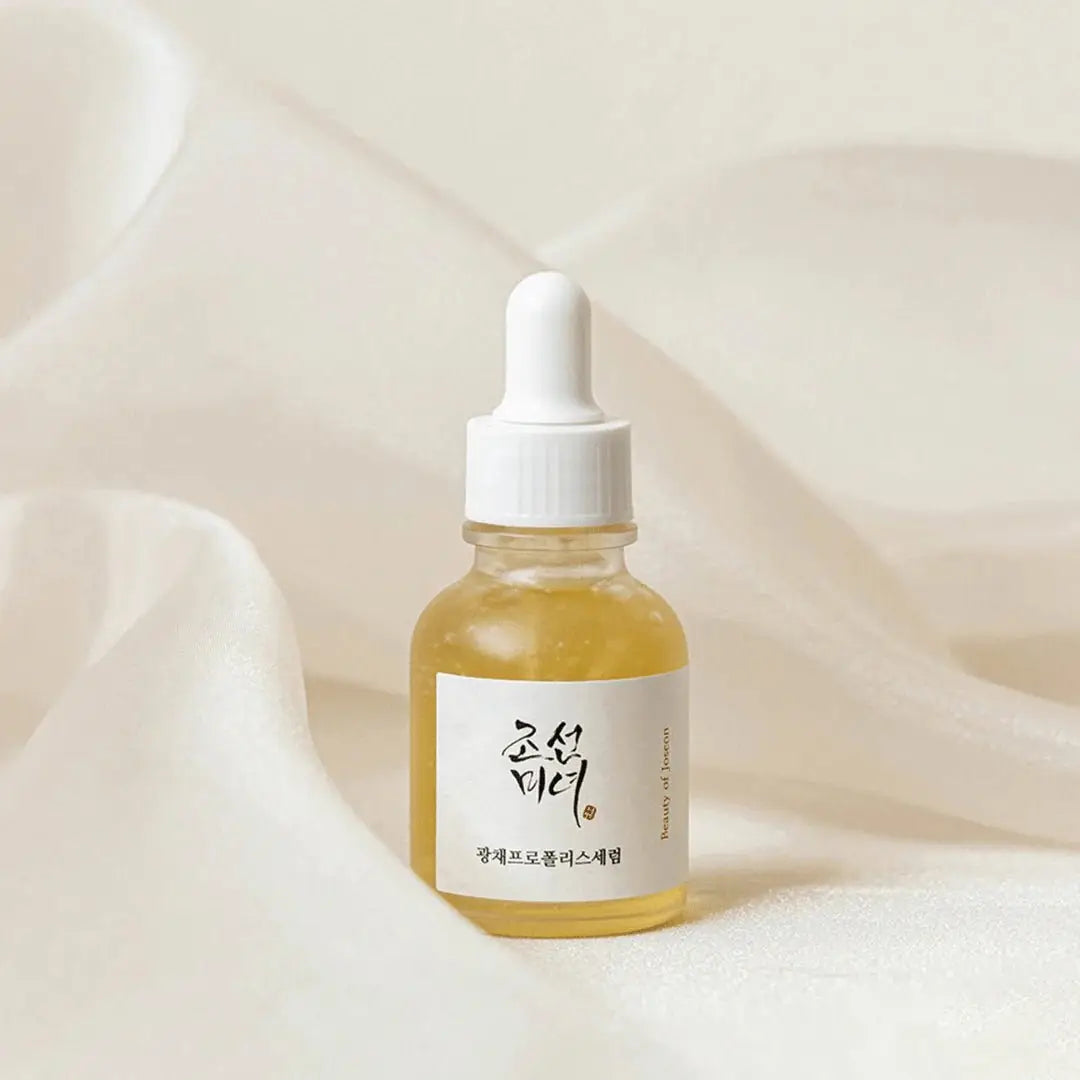 Skincare serum bottle with dropper on a soft beige fabric background