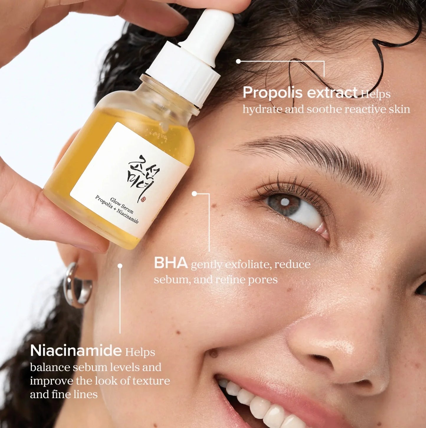 Skincare serum bottle being applied to a person's face with text highlighting ingredients.