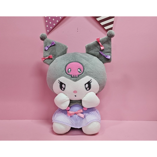 Kuromi plush doll with pink and purple ribbons and a lavender striped skirt, seated against a pink backdrop.