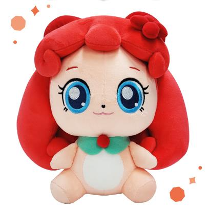 Catch! Teenieping Owwping plush doll with red curly hair, blue sparkly eyes, a green holly-style collar, and a sweet smile, seated against a white background with orange sparkles.