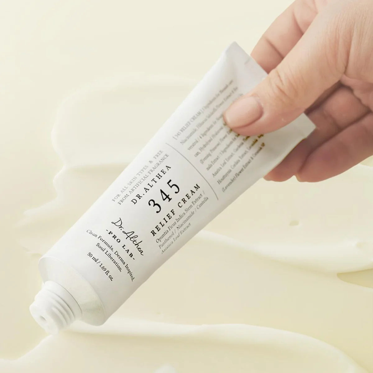 Hand holding a tube of Dr. Althea 345 Relief Cream against a light background