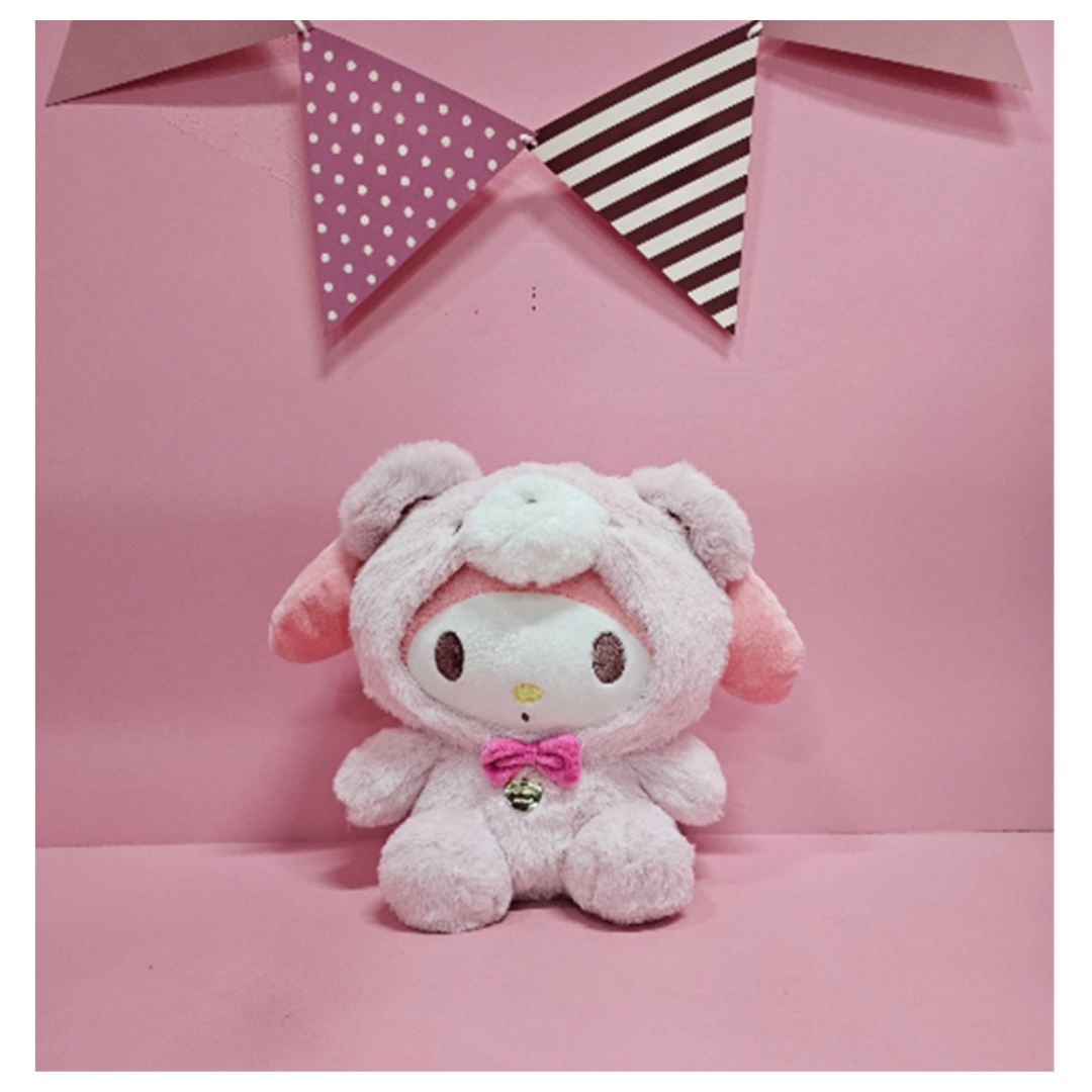 My Melody plush dressed in a fluffy bear hoodie with a pink bow and bell, displayed on a pink background.