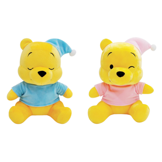 Pair of Winnie the Pooh plush toys in pastel pajamas — one wearing a blue sleep shirt and hat with closed eyes, the other in a pink shirt and hat with a winking expression