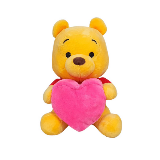 Winnie the Pooh plush toy holding a large pink heart, wearing a red shirt, sitting upright against a white background — perfect for Valentine's Day or gift occasions.