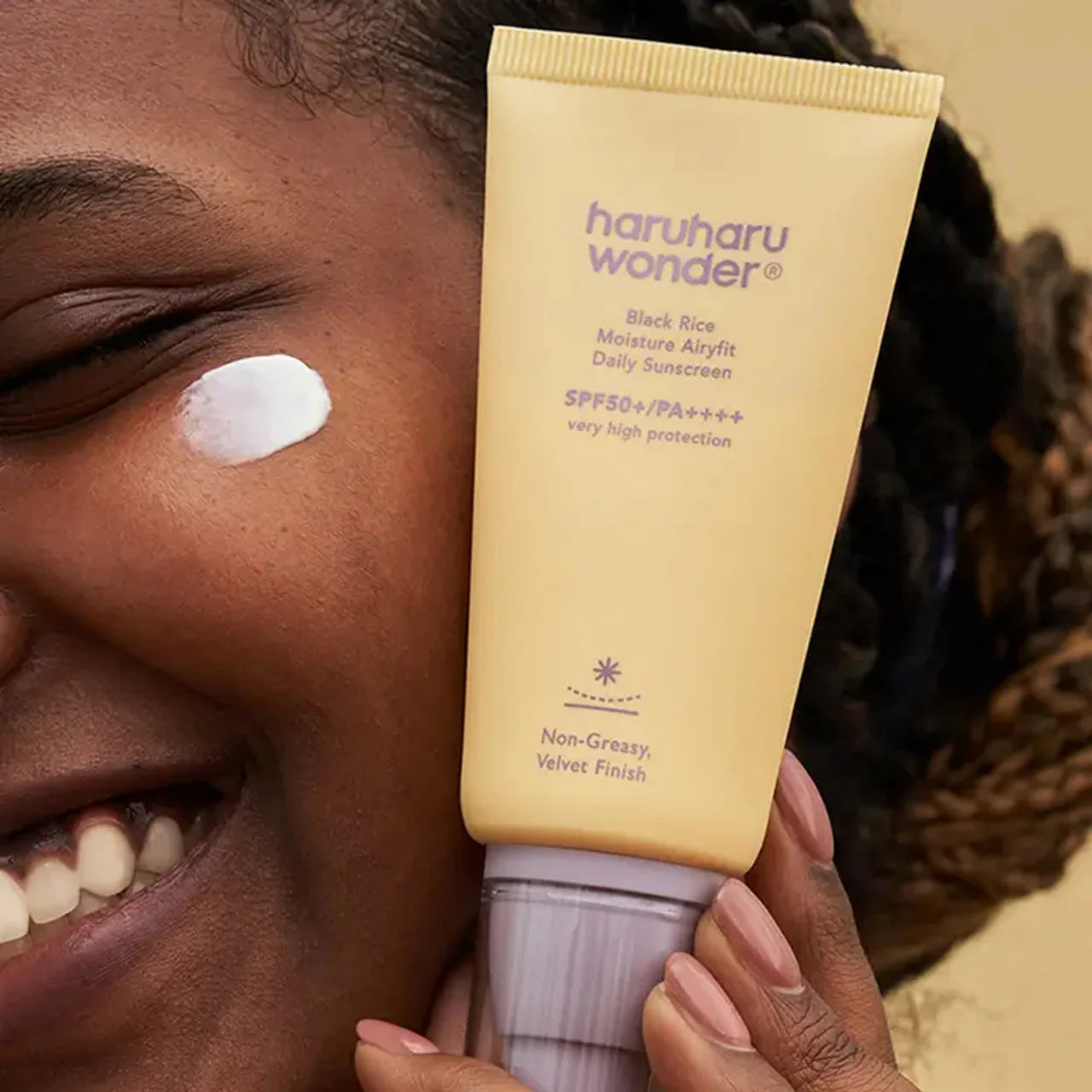 Person applying haruharu wonder sunscreen to their face