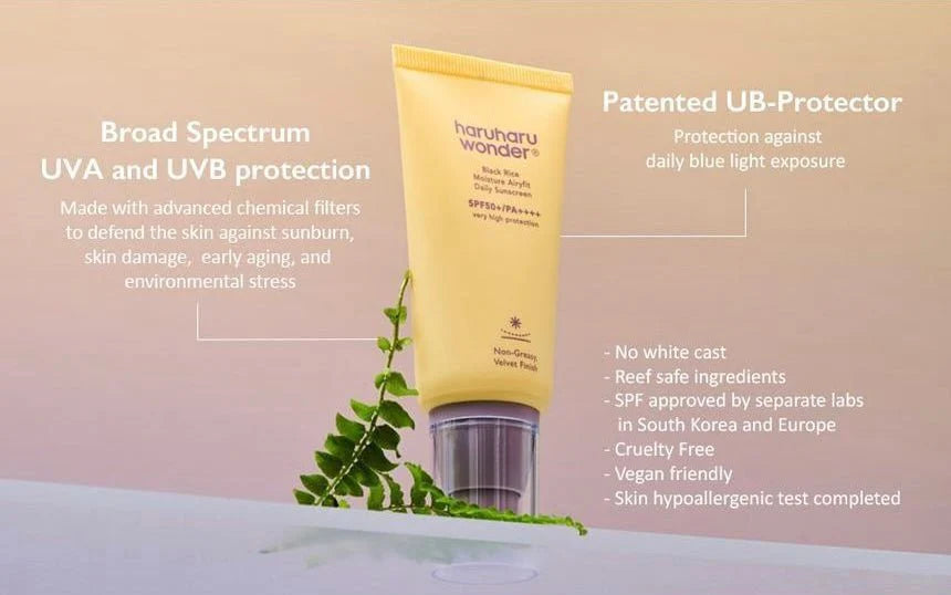 Yellow sunscreen bottle with green leaves on a pink background